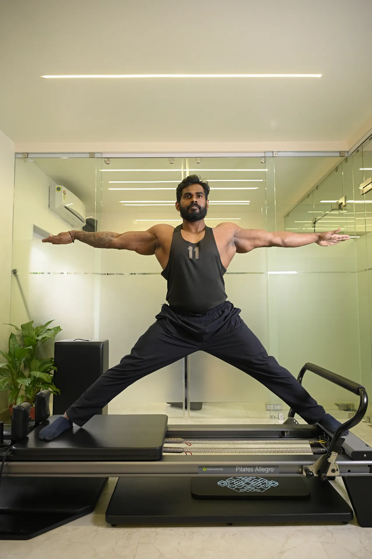 Man practicing Pilates exercise on reformer equipment